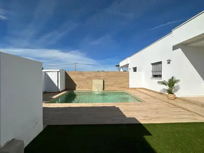 a swimming pool in the backyard of a house at Sumatra Chalet in Chiclana de la Frontera
