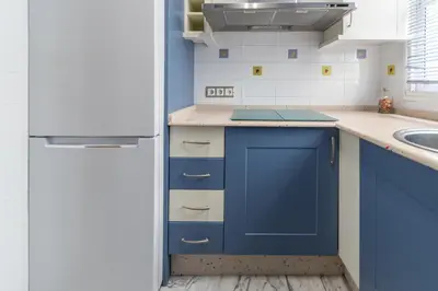 a kitchen with blue cabinets and a blue refrigerator at Apartamento Cadiz Be Kind in Cádiz