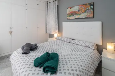 a bedroom with a bed with green towels on it at Apartamento Cadiz Be Kind in Cádiz