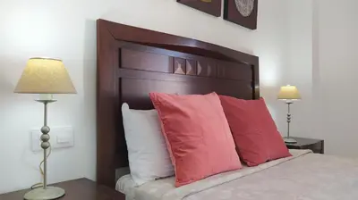 a bedroom with a bed with red pillows and two lamps at Sherryflat Porvenir in Jerez de la Frontera