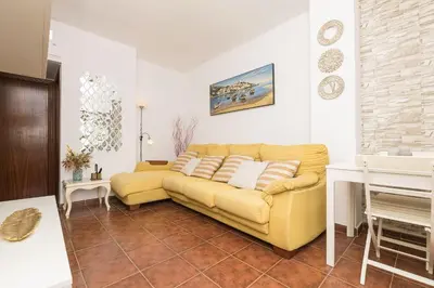 a living room with a yellow couch in a room at El Deseo in Chiclana de la Frontera