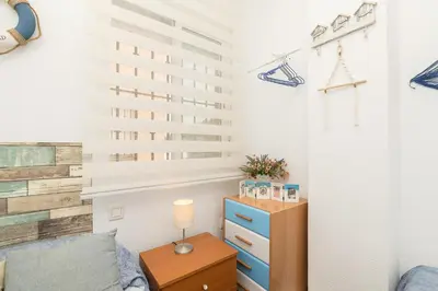 a bedroom with a bed and a dresser and a night stand at El Deseo in Chiclana de la Frontera