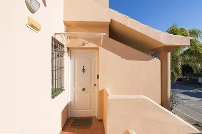 a white house with a white door and stairs at El Deseo in Chiclana de la Frontera