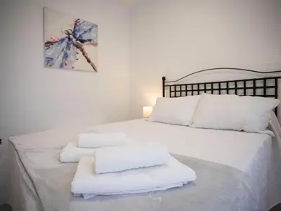 a bedroom with a white bed with towels on it at Colon 1 in El Puerto de Santa María