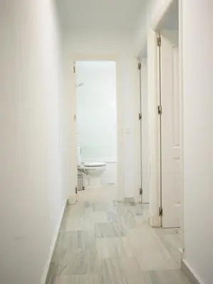 an empty white room with a toilet and a window at Colon 1 in El Puerto de Santa María