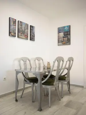 a dining room table and four chairs in front of a wall at Colon 1 in El Puerto de Santa María