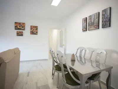 a white dining room with a white table and chairs at Colon 1 in El Puerto de Santa María
