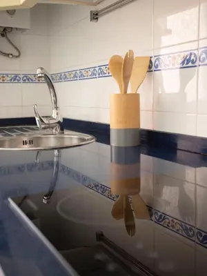 a kitchen counter with a sink and a wooden utensils at Colon 1 in El Puerto de Santa María