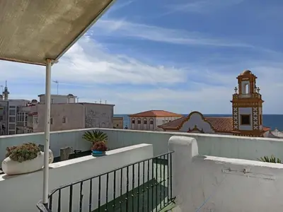 a balcony with a view of a clock tower at ÁTICO SANTA MARÍA in Cádiz