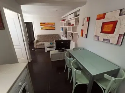 a living room with a table and chairs and a couch at ÁTICO SANTA MARÍA in Cádiz