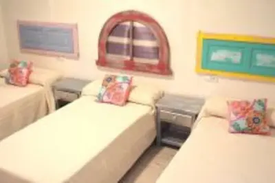 a room with two beds and a window at APARTAMENTO VEEDOR 19 DÍAS Y MUCHAS NOCHES in Cádiz