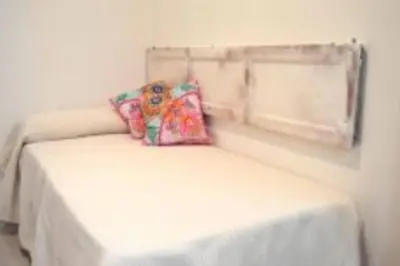 a white bed with a teddy bear sitting on top of it at APARTAMENTO VEEDOR 19 DÍAS Y MUCHAS NOCHES in Cádiz