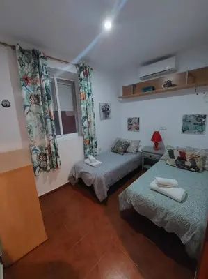 a bedroom with two beds and a window at APARTAMENTO SANTA MARÍA in Cádiz