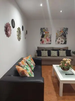 a living room with a black couch and a table at APARTAMENTO SANTA MARÍA in Cádiz