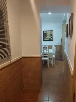 a hallway with a table and a dining room at APARTAMENTO SANTA MARÍA in Cádiz
