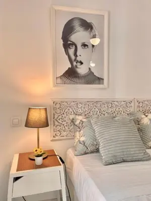 a bedroom with a black and white picture above a bed at GATU La Joya Escondida in El Puerto de Santa María