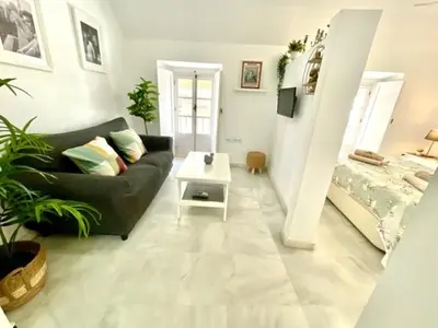 a living room with a couch and a bed at GATU La Joya Escondida in El Puerto de Santa María