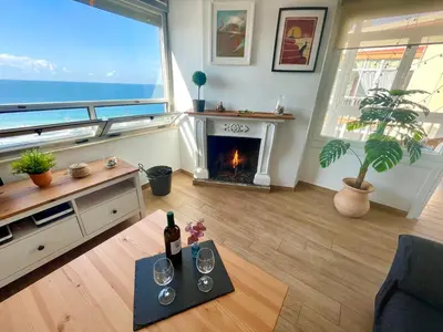 a living room with a fireplace and a view of the ocean at GATU Casa Muse junto a la playa, vista al mar, aire acc, terraza, wifi y chimenea 