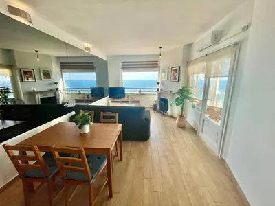 a living room with a table and a dining room at GATU Casa Muse junto a la playa, vista al mar, aire acc, terraza, wifi y chimenea 