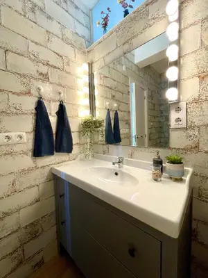 a bathroom with a sink and a mirror at GATU Casa Muse junto a la playa, vista al mar, aire acc, terraza, wifi y chimenea 