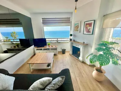 a living room with a couch and a fireplace at GATU Casa Muse junto a la playa, vista al mar, aire acc, terraza, wifi y chimenea 