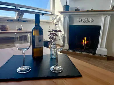 a bottle of wine and two wine glasses on a table at GATU Casa Muse junto a la playa, vista al mar, aire acc, terraza, wifi y chimenea 