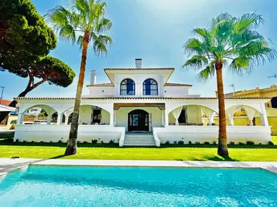 a house with palm trees and a swimming pool at Villa Velero - Ole Solutions in Sanlúcar de Barrameda