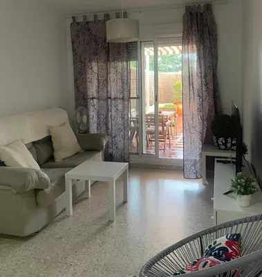 a living room with a couch and a table at Puerta de Doñana: Playa y centro a un paso. in Sanlúcar de Barrameda