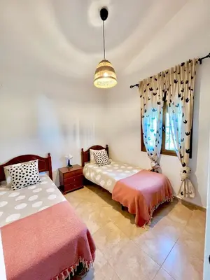 a bedroom with two beds and a window at Casa Con Encanto 2 SOLO FAMILIAS in Conil de la Frontera