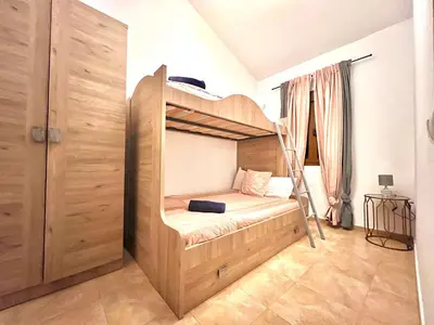 a bedroom with a bunk bed with a ladder at Casa Con Encanto 2 SOLO FAMILIAS in Conil de la Frontera
