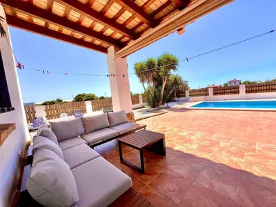 a couch on a patio next to a swimming pool at Casa Con Encanto 2 SOLO FAMILIAS in Conil de la Frontera