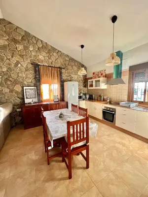a kitchen with a table and a stone wall at Casa Con Encanto 2 SOLO FAMILIAS in Conil de la Frontera