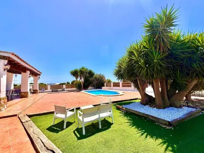 a patio with a table and two chairs and a pool at Casa Con Encanto 2 SOLO FAMILIAS in Conil de la Frontera