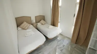 two beds in a small room with a mirror at Allo Apartments Larga Hideaway Parking Centro 2 Habitaciones in Jerez de la Frontera