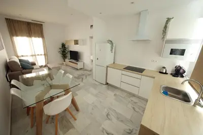 a kitchen and living room with a glass table at Allo Apartments Larga Hideaway Parking Centro 2 Habitaciones in Jerez de la Frontera