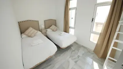 a bedroom with two beds and a window at Allo Apartments Larga Hideaway Parking Centro 2 Habitaciones in Jerez de la Frontera