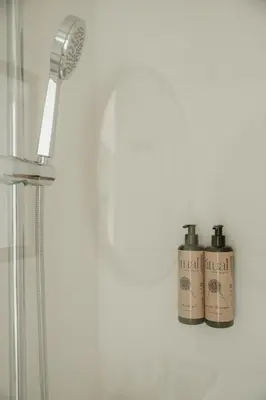 two bottles of shampoo are sitting on a shelf in a shower at Olivar de Belén in Jerez de la Frontera