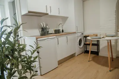 a kitchen with white cabinets and a table with a plant at Olivar de Belén in Jerez de la Frontera