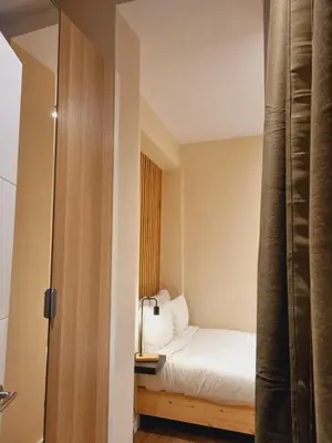 a small room with a bed and a mirror at AUJADA CENTRO in Cádiz
