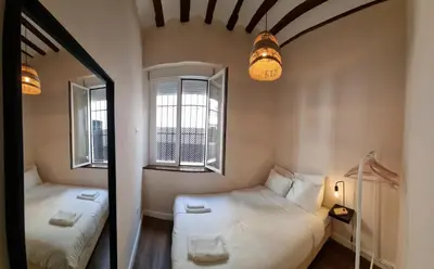 two beds in a small room with two windows at AUJADA CENTRO in Cádiz