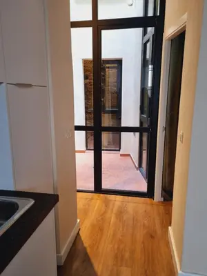 a kitchen with a door leading into a room with a wooden floor at AUJADA CENTRO in Cádiz