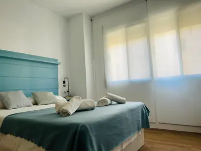 a bedroom with a bed with towels on it at Rinconcito Gaditano con GARAJE al lado de la PLAYA in Cádiz