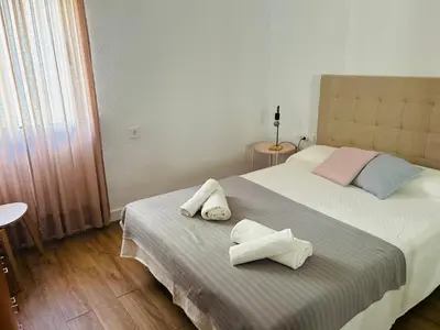 a bedroom with a large bed with towels on it at Rinconcito Gaditano con GARAJE al lado de la PLAYA in Cádiz