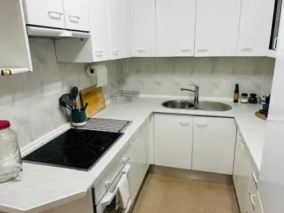 a kitchen with white cabinets and a sink at Rinconcito Gaditano con GARAJE al lado de la PLAYA in Cádiz