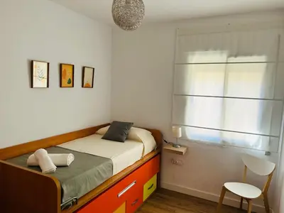 a small bedroom with a bed and a window at Rinconcito Gaditano con GARAJE al lado de la PLAYA in Cádiz