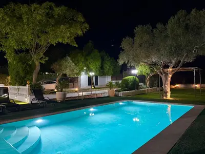 a swimming pool in a yard at night at VILLA MACARENA in Espera