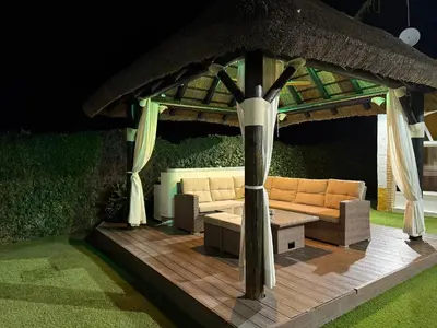 a gazebo with a couch on a wooden deck at VILLA MACARENA in Espera