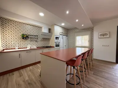 a kitchen with a counter and a bar with stools at VILLA MACARENA in Espera
