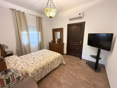 a bedroom with a bed and a flat screen tv at VILLA MACARENA in Espera
