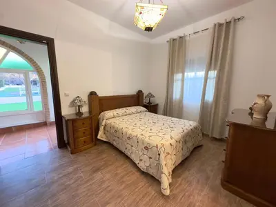 a bedroom with a bed and a dresser and a window at VILLA MACARENA in Espera